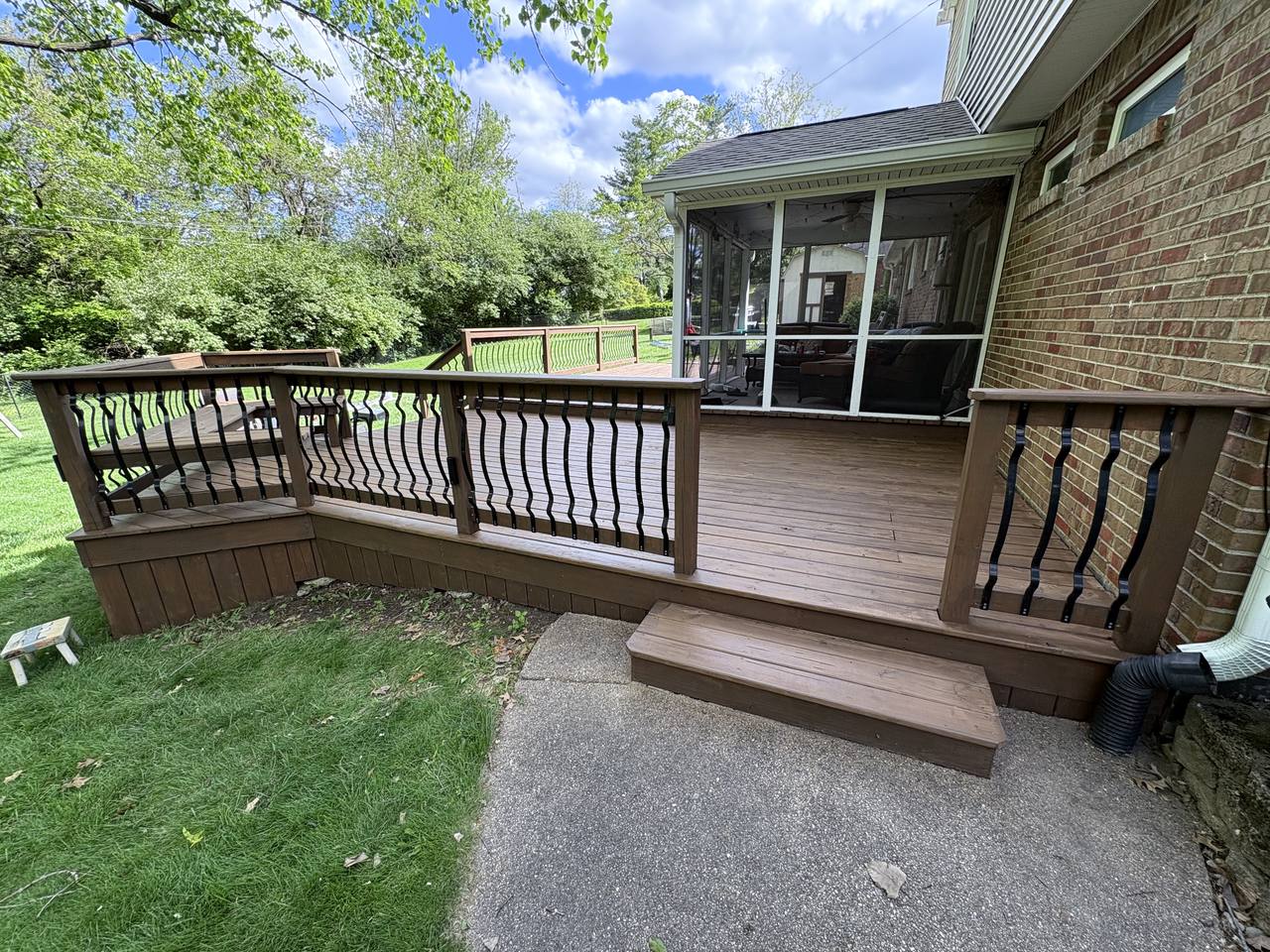 The same deck after cleaning and staining, boards and railings a rich warm brown